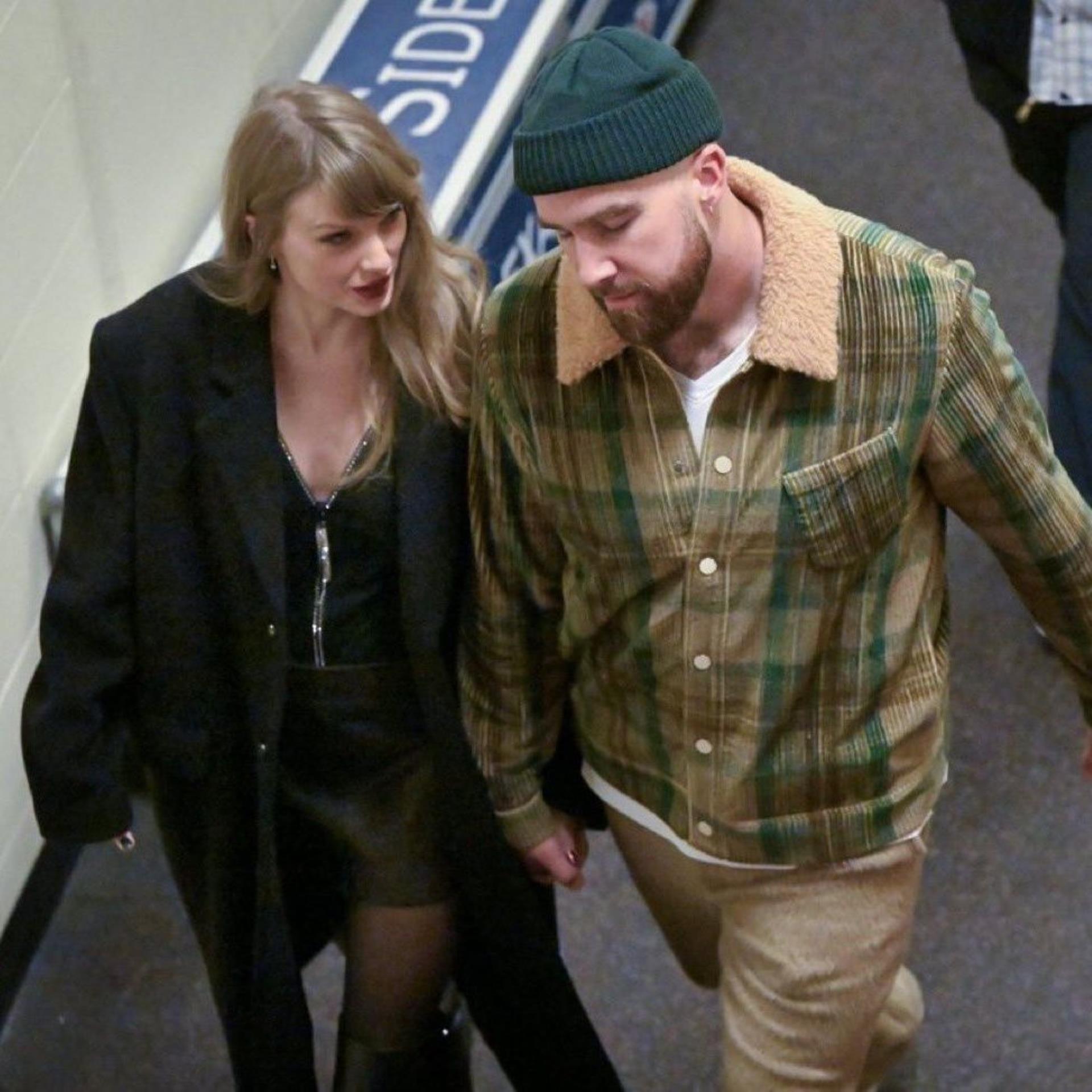 Taylor Swift holding hands with Travis Kelce while leaving his game.