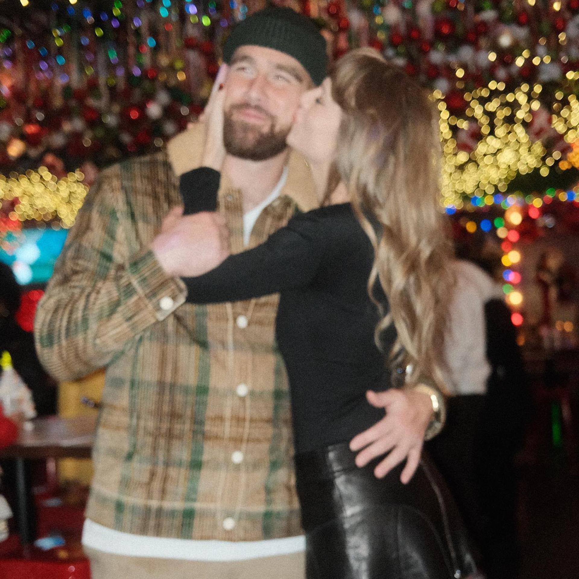 Taylor Swift kissing Travis Kelce's cheek.